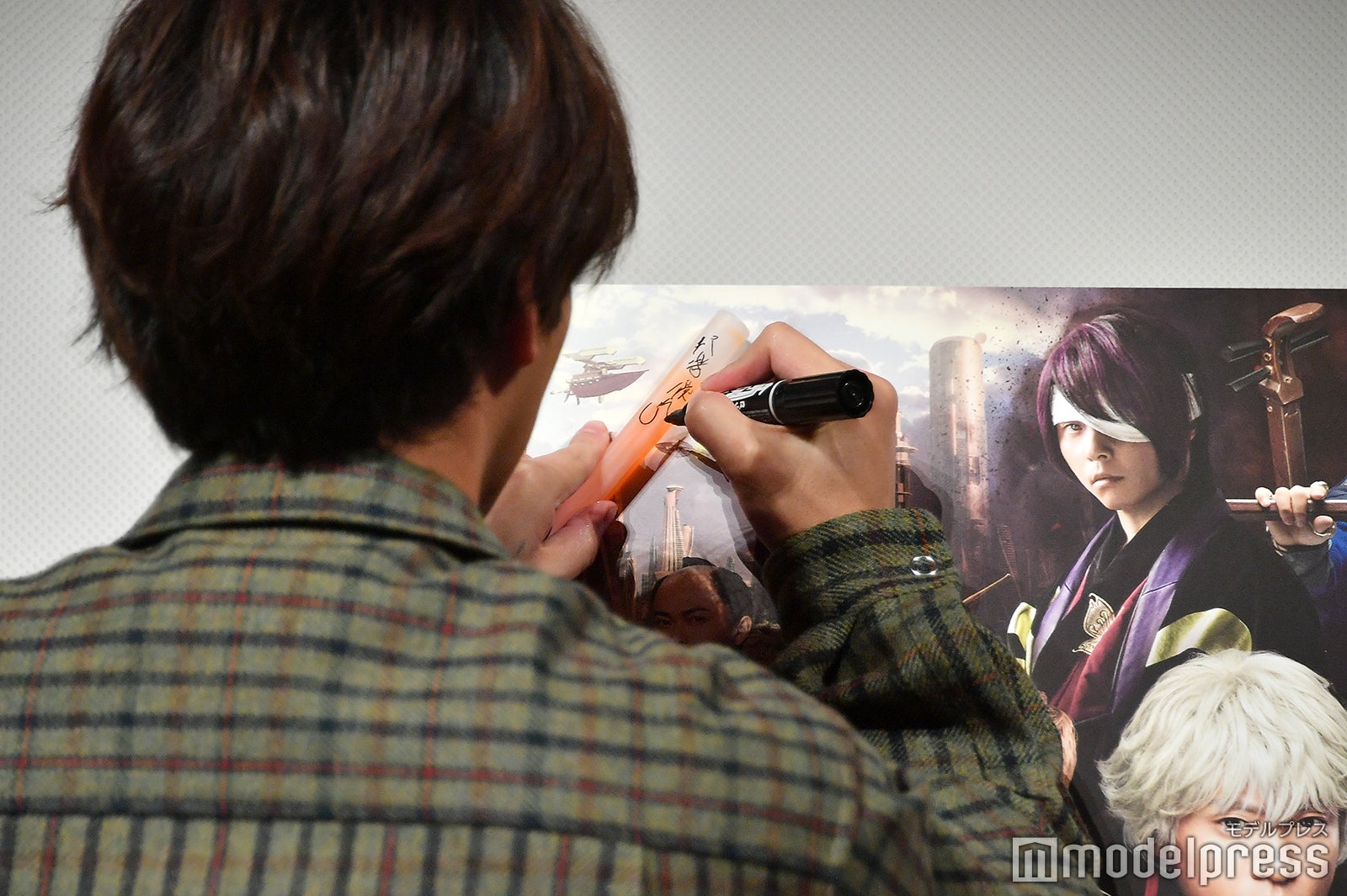 ペンライトにサインを入れる柳楽優弥 （C）モデルプレス