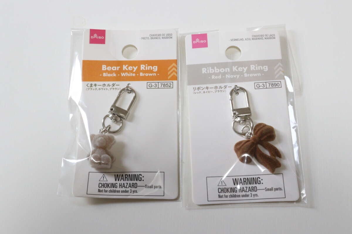 ダイソーのくまキーホルダー（ブラック、ホワイト、ブラウン）とリボンキーホルダー（レッド、ネイビー、ブラウン）のパッケージ
