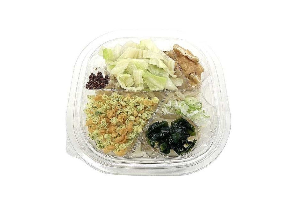 透明容器に入った吉田の冷しうどん。キャベツや油揚げがのる 透明容器に入った吉田の冷しうどん。キャベツや油揚げがのる
