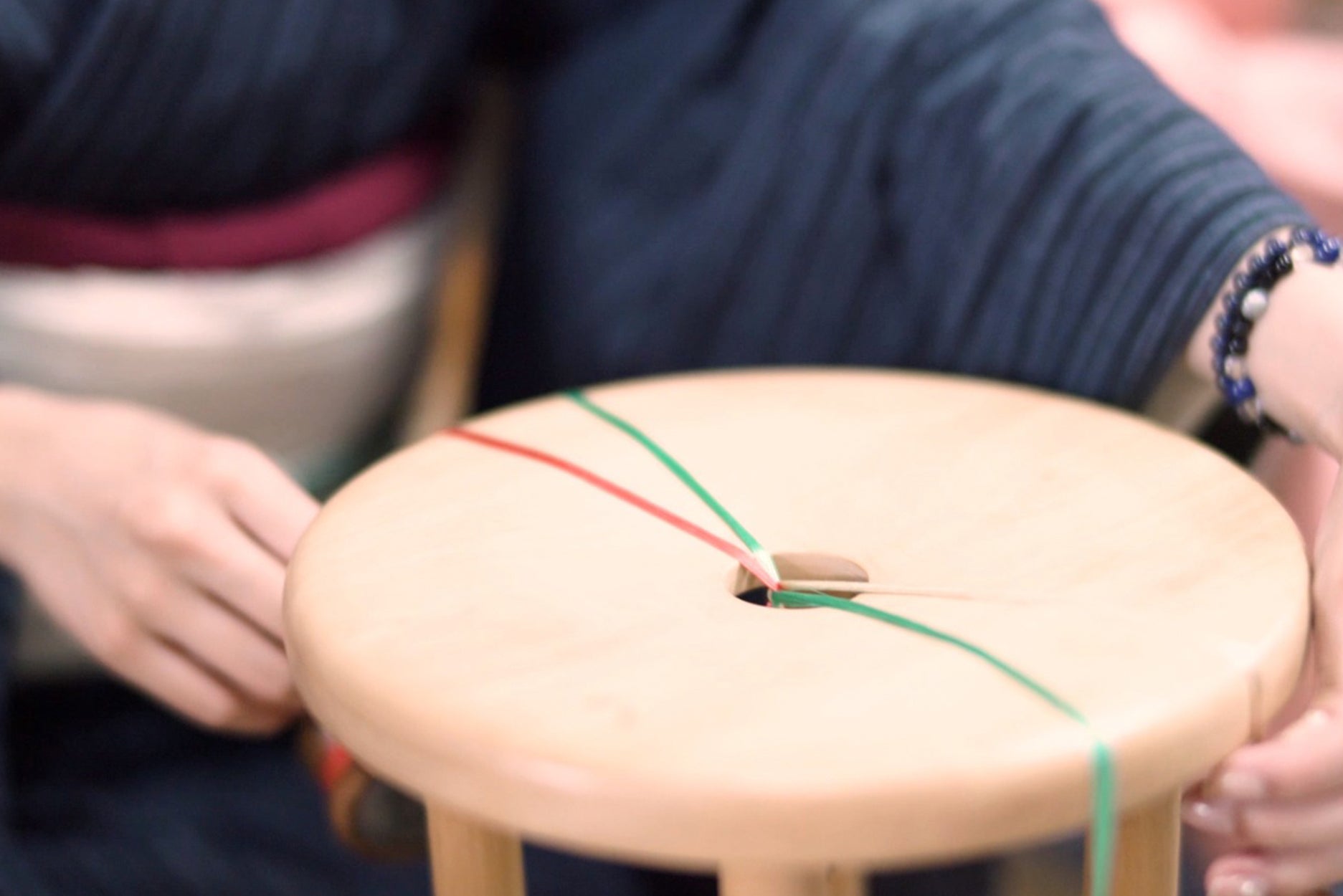 色とりどりの紐を手作業で組んでいく／小山市