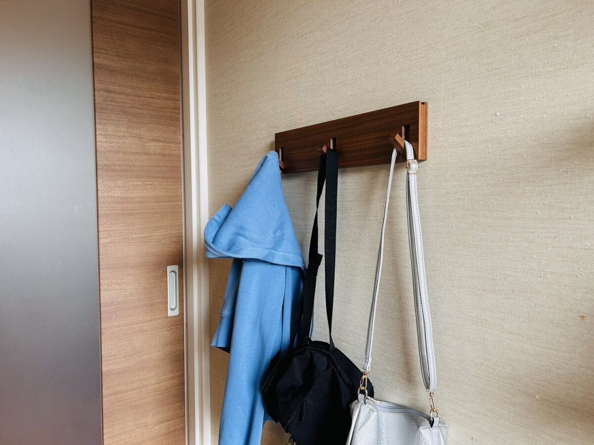 壁の木製フックにパーカーやバッグを掛けた玄関収納 壁の木製フックにパーカーやバッグを掛けた玄関収納