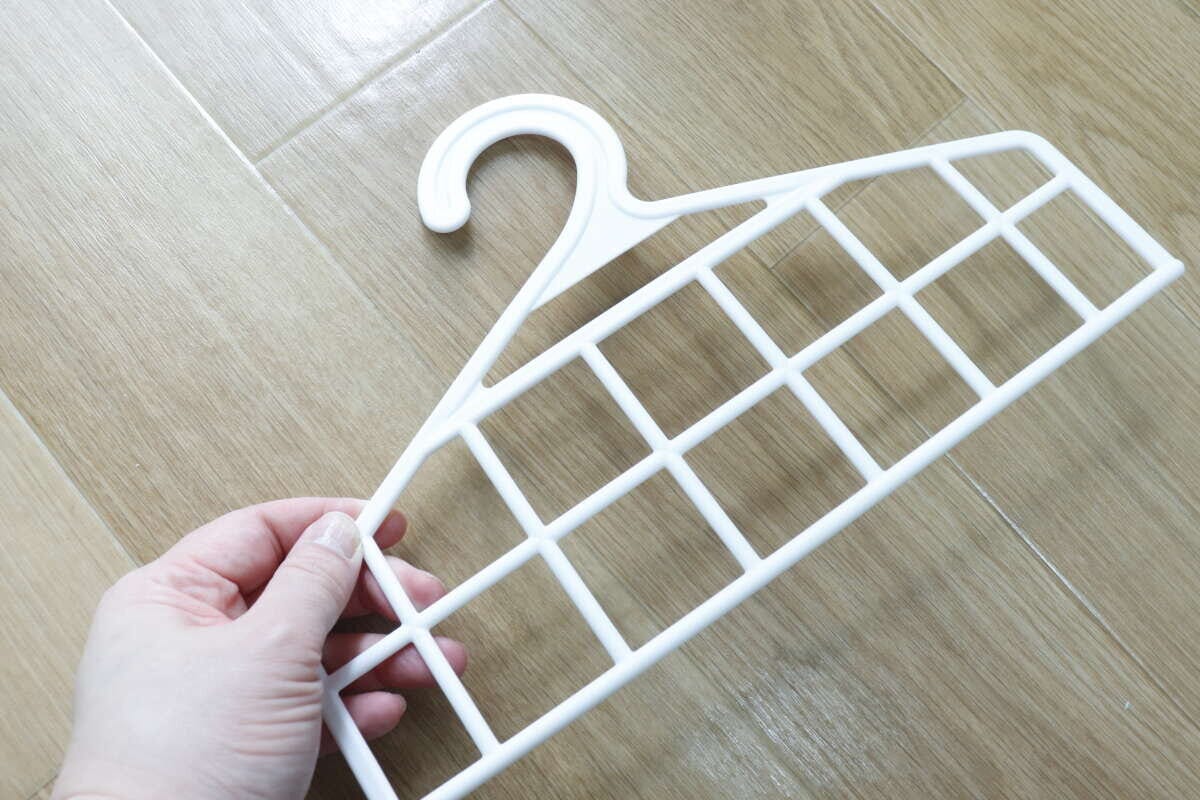 白いメッシュのハンガー部分を手に持つ
