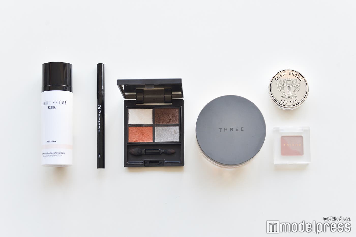 (左から)【BOBBI BROWN】エクストラ イルミネイティング モイスチャー バーム 03ピンクグロウ、【D-UP】シルキーリキッドアイライナーWP BK、【Celvoke】ヴォランタリーベイシス アイパレット 04、【THREE】アルティメイトダイアフェネス ルースパウダー トランスルーセント 02、(右上)【BOBBI BROWN】リップバーム SPF15、(右下)【to/one】ペタル アイシャドウ 14(C)モデルプレス