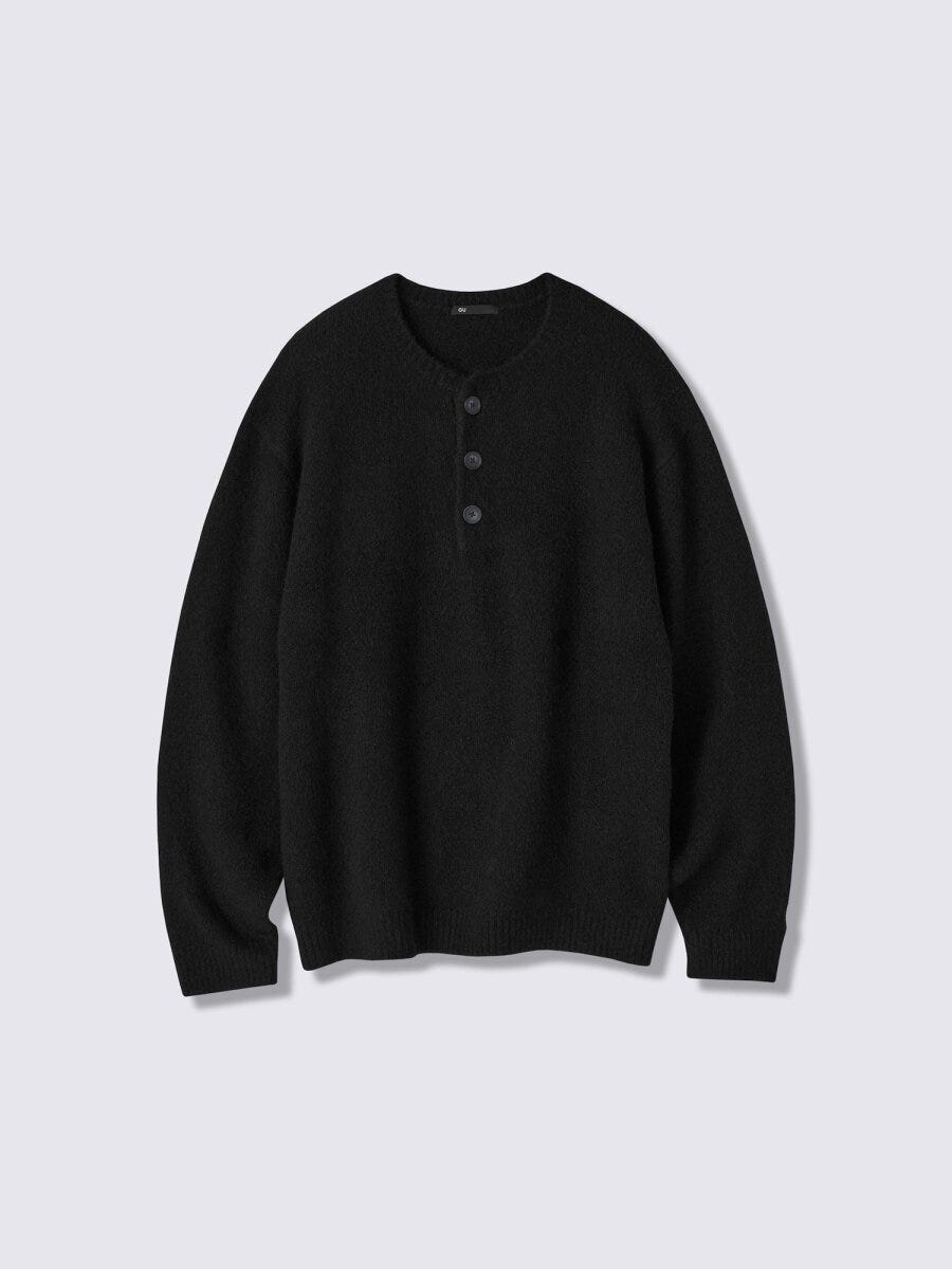 黒色のヘンリーネックセーターを平置きにした俯瞰