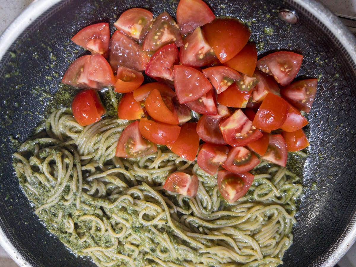 フライパンのしそベーゼパスタの上にカットしたミディトマトが加えられている フライパンのしそベーゼパスタの上にカットしたミディトマトが加えられている
