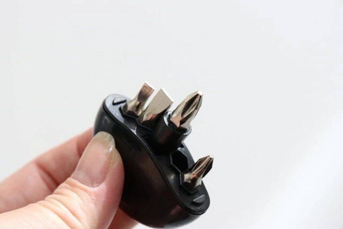 指で持ったキーホルダー型ドライバーからビットが出ている様子