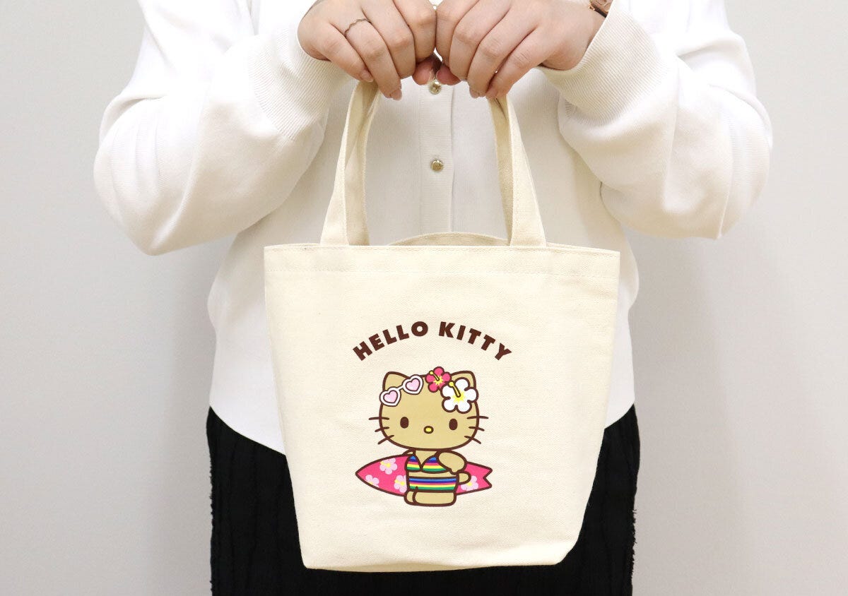 白い服の女性がハローキティのミニトートバッグを手に持っている