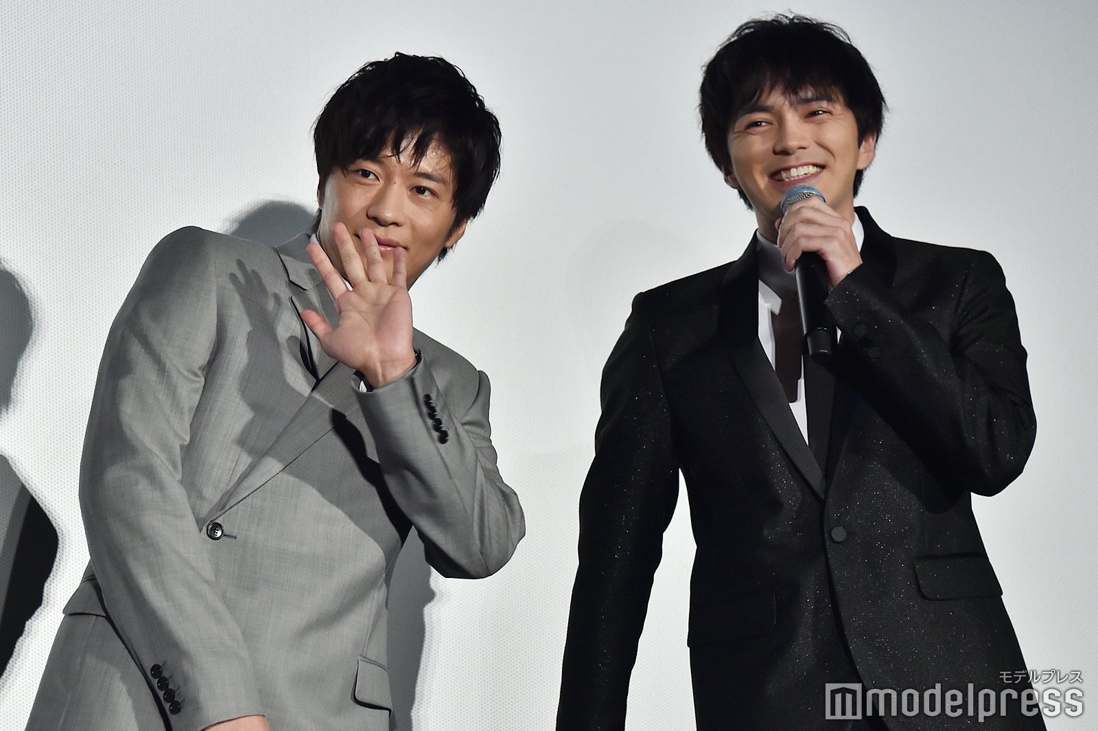 ライブビューイングのカメラを林遣都（右）に教えてもらい手をふる田中圭（左）／（C）モデルプレス