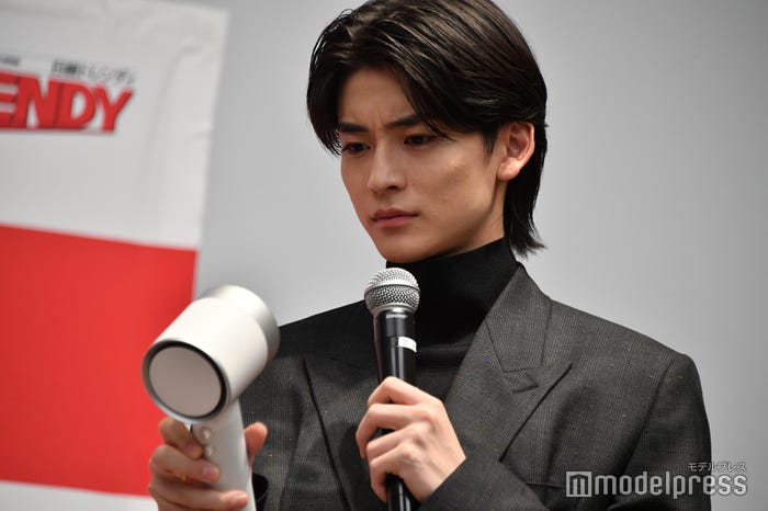 光ヘアケアドライヤーをまじまじと見つめる高橋文哉 (C)モデルプレス