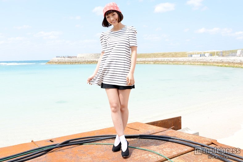 沖縄の青空と海をバックにして、笑顔に