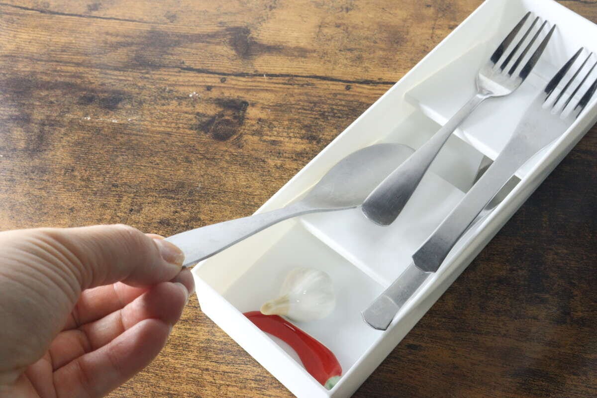 ケースからスプーンを取り出そうとしている手元