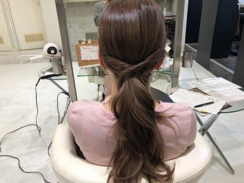 右サイドの毛束をねじって、交差させて左側の耳裏にピンで留める