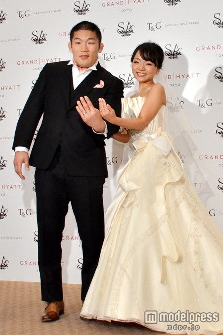 結婚指輪を見せる石井慧選手と林明日香