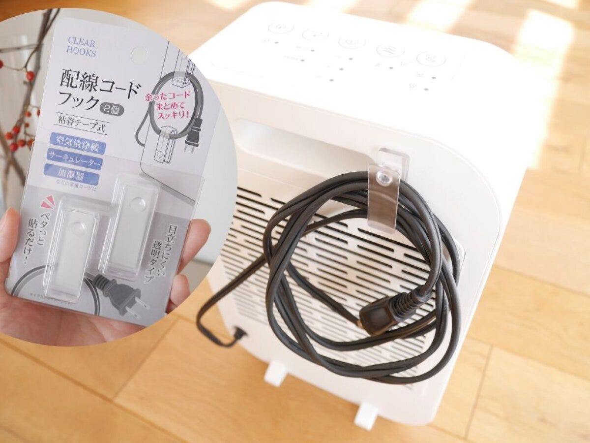 白い空気清浄機の背面にクリアフックを貼り付け黒い電源コードを巻き付けている様子 白い空気清浄機の背面にクリアフックを貼り付け黒い電源コードを巻き付けている様子