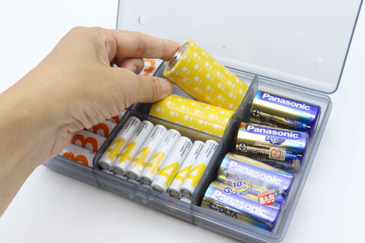 手が乾電池収納ケースから単1形の乾電池を取り出している様子