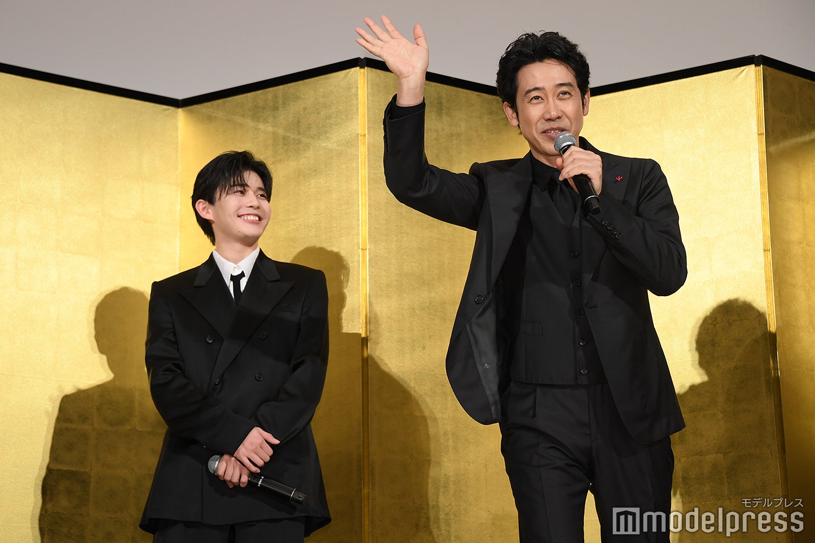 中継カメラに陽気に手を振る大泉洋を見て笑顔になる長尾謙杜（C）モデルプレス