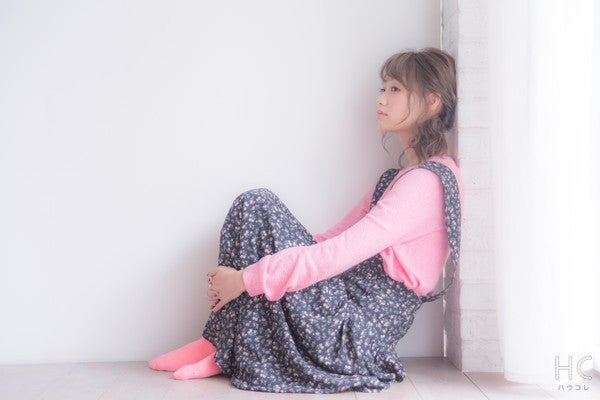壁にもたれる寂しそうな女性