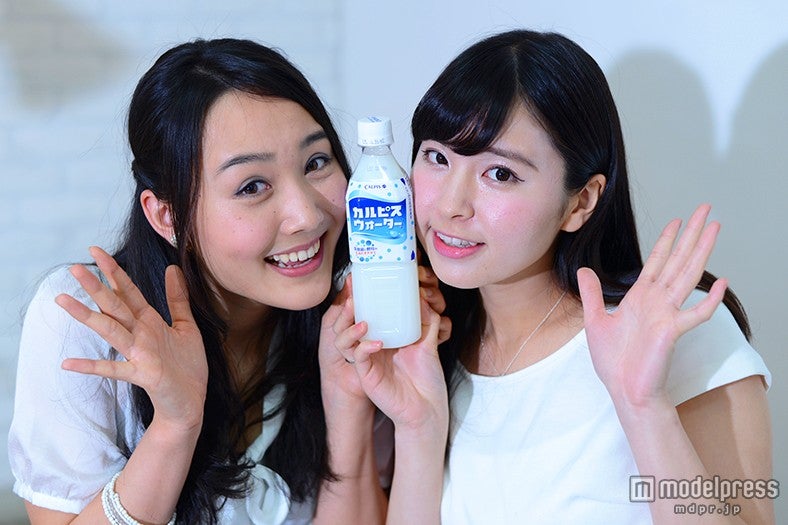 2人で1本を挟んで「あいあいカルピスウォーターポーズ」／2014ミス関西学院大学・中山さん、2014ミス慶応義塾大学・角谷さん