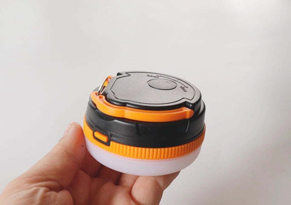 手のひらに乗せた黒とオレンジの小型ランタン 手のひらに乗せた黒とオレンジの小型ランタン