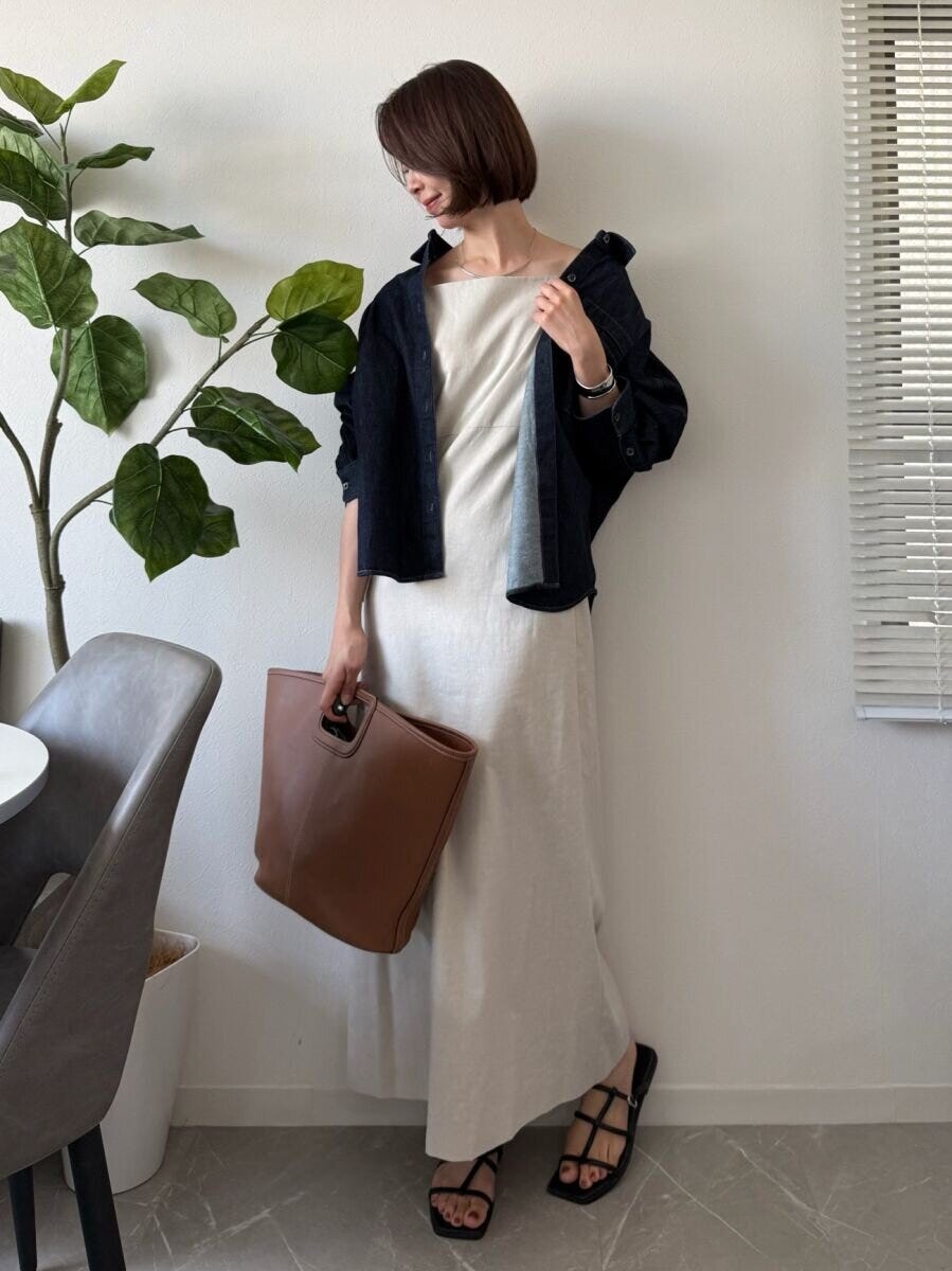 白いワンピースにデニムジャケットを肩掛けした女性 白いワンピースにデニムジャケットを肩掛けした女性