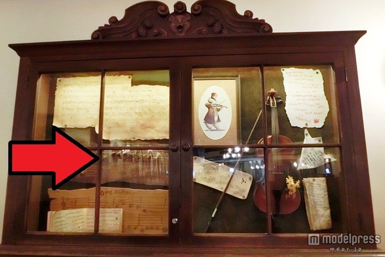 飾り棚の中の木の楽譜に注目