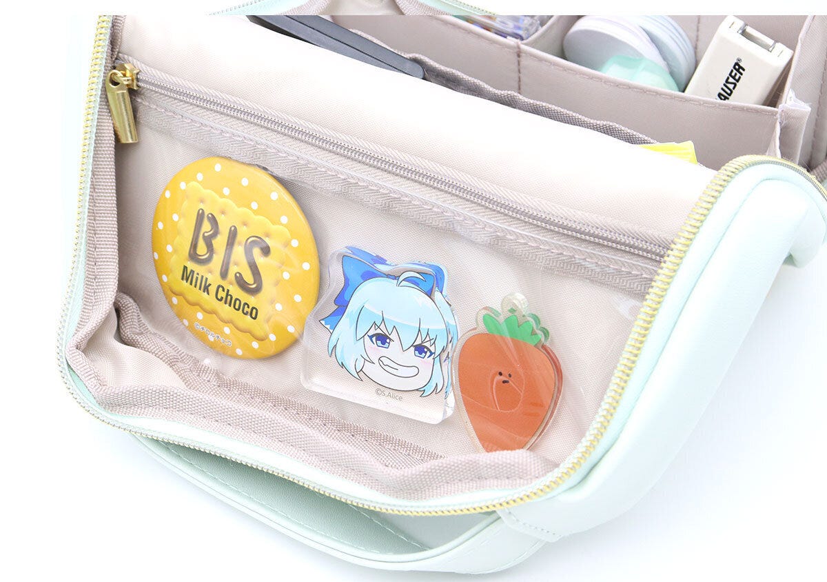 ポーチのクリアポケットに缶バッジとアクリルスタンドが入っている ポーチのクリアポケットに缶バッジとアクリルスタンドが入っている