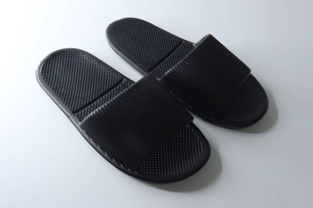 白い背景に並べられたダイソーの黒いサンダル2足