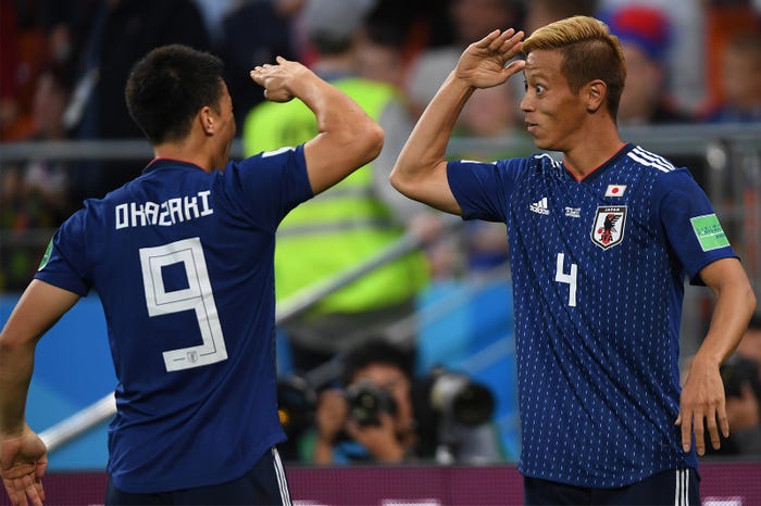 敬礼ポーズをする岡崎慎司、本田圭佑(Photo by Getty Images)