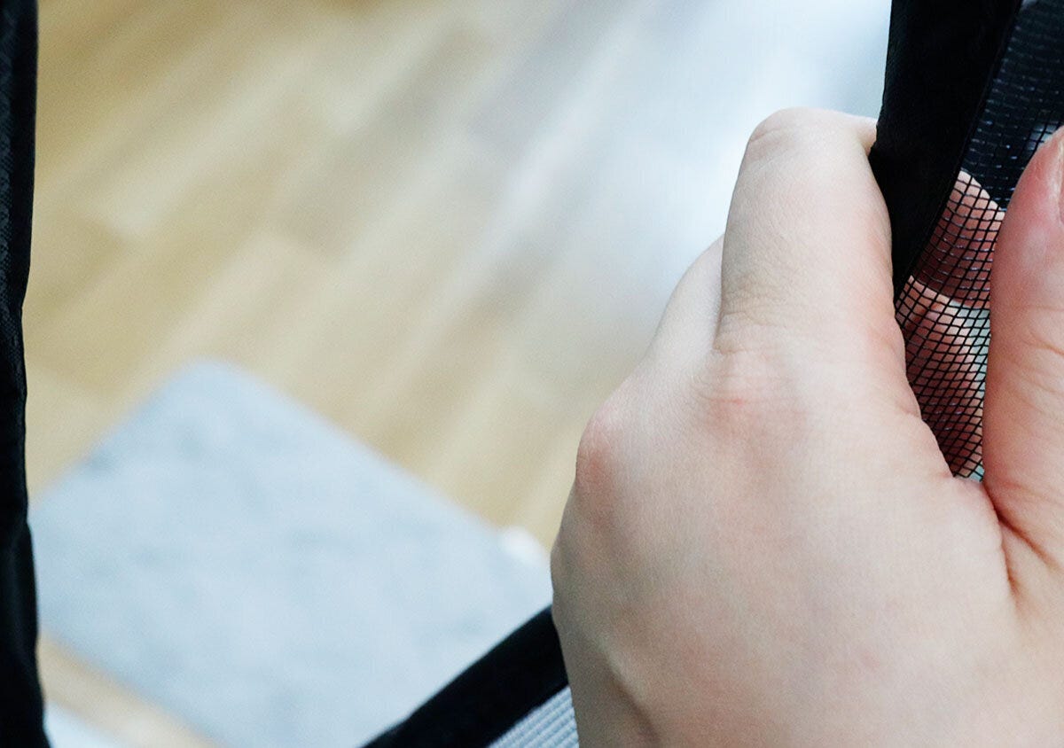 網戸の中央にあるマグネット部分を手で開けている様子