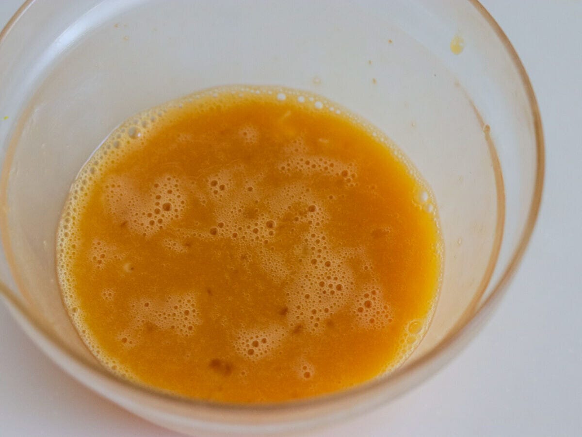 ガラスボウルに卵と砂糖を混ぜ合わせた黄色い卵液の俯瞰写真
