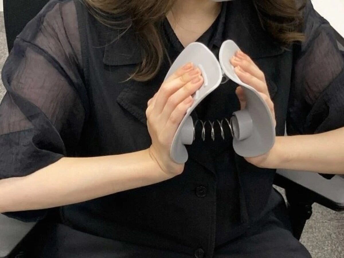 女性が内転筋トレーニング器を胸の前で使う