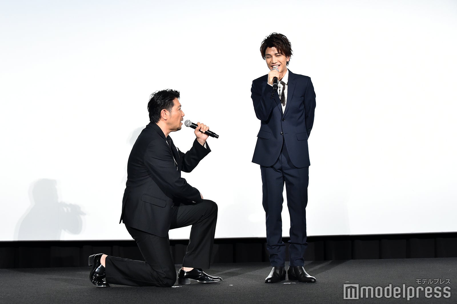 岩田剛典（右）にひざまずく別所哲也（左）（C）モデルプレス