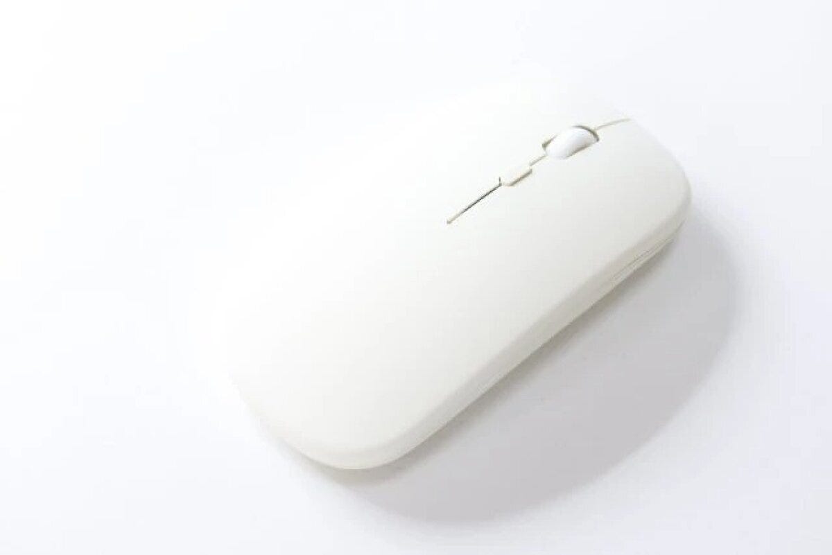 シンプルな白い薄型ワイヤレスマウスを斜め上から捉えた俯瞰写真 シンプルな白い薄型ワイヤレスマウスを斜め上から捉えた俯瞰写真