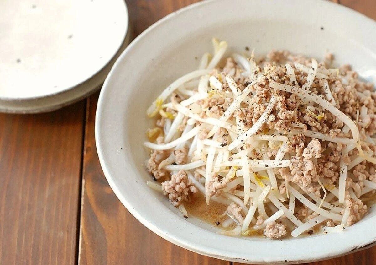 もやしと豚ひき肉を炒め、ブラックペッパーをふったコクうま炒めを、生成り色の器に盛った写真