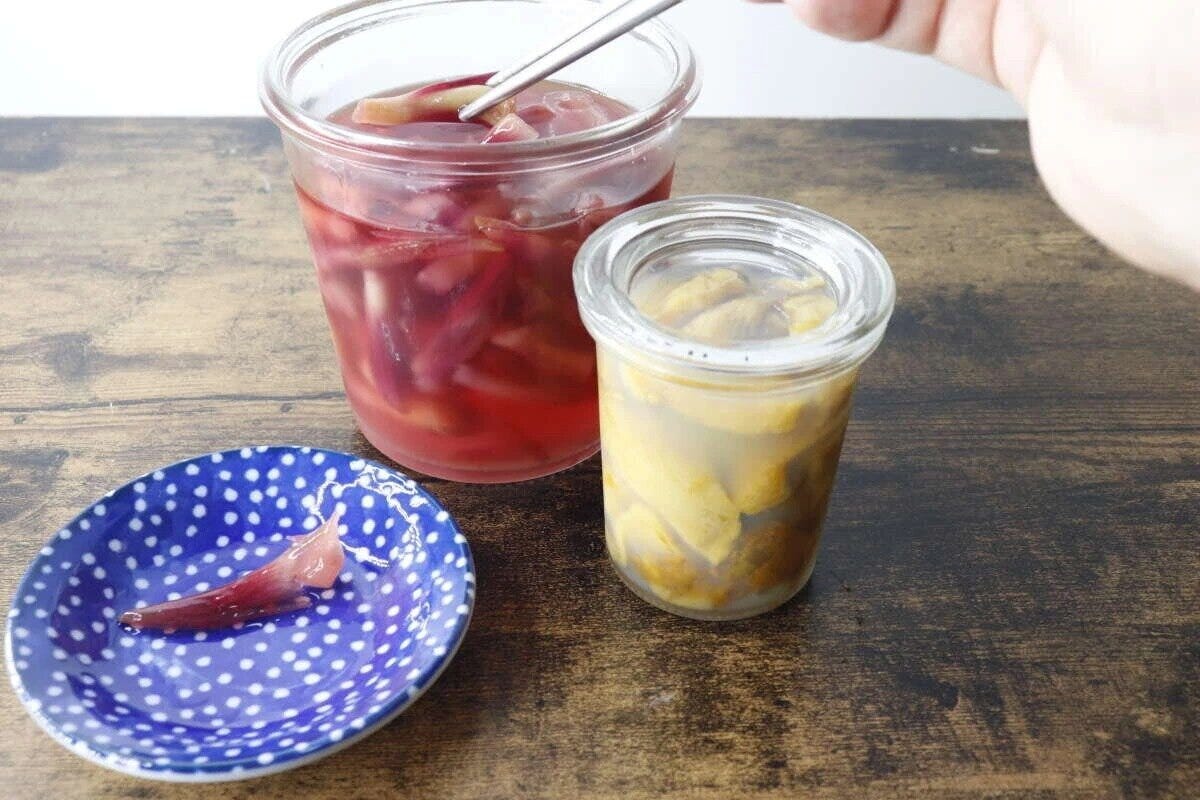 青い豆皿に赤い漬物、奥に瓶詰めの漬物が並ぶ 青い豆皿に赤い漬物、奥に瓶詰めの漬物が並ぶ