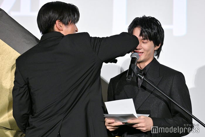 花束で手が塞がっているため肘で佐野勇斗の涙を拭く目黒蓮(C)モデルプレス