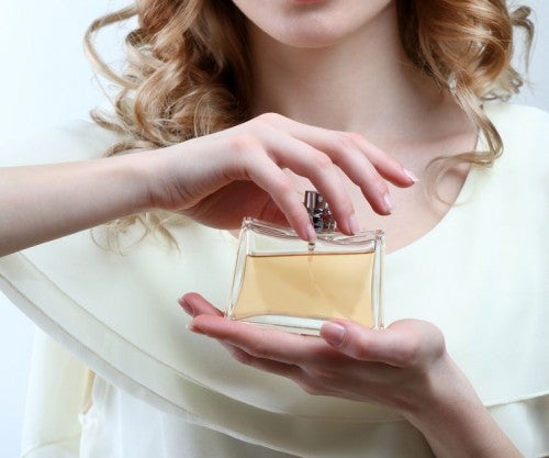 香水瓶を手に持つ女性