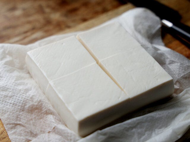 絹豆腐は、表面の水気をキッチンペーパーに包んでふき取ったら、4等分に切る。