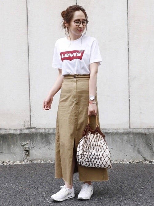 ロゴTシャツにチノスカートを履いた女性