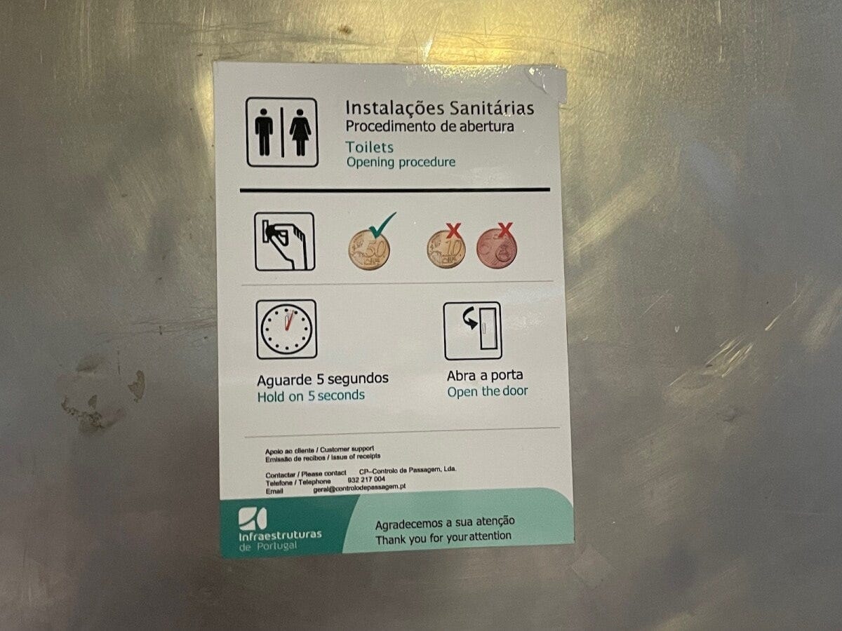 有料トイレのドアに貼り出されたドアの開け方の説明。50セント投入後、5秒待ってドアを開けるとのこと