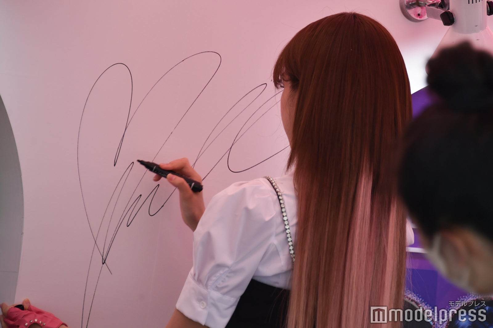 サインを入れるチョ・ユリ（C）モデルプレス