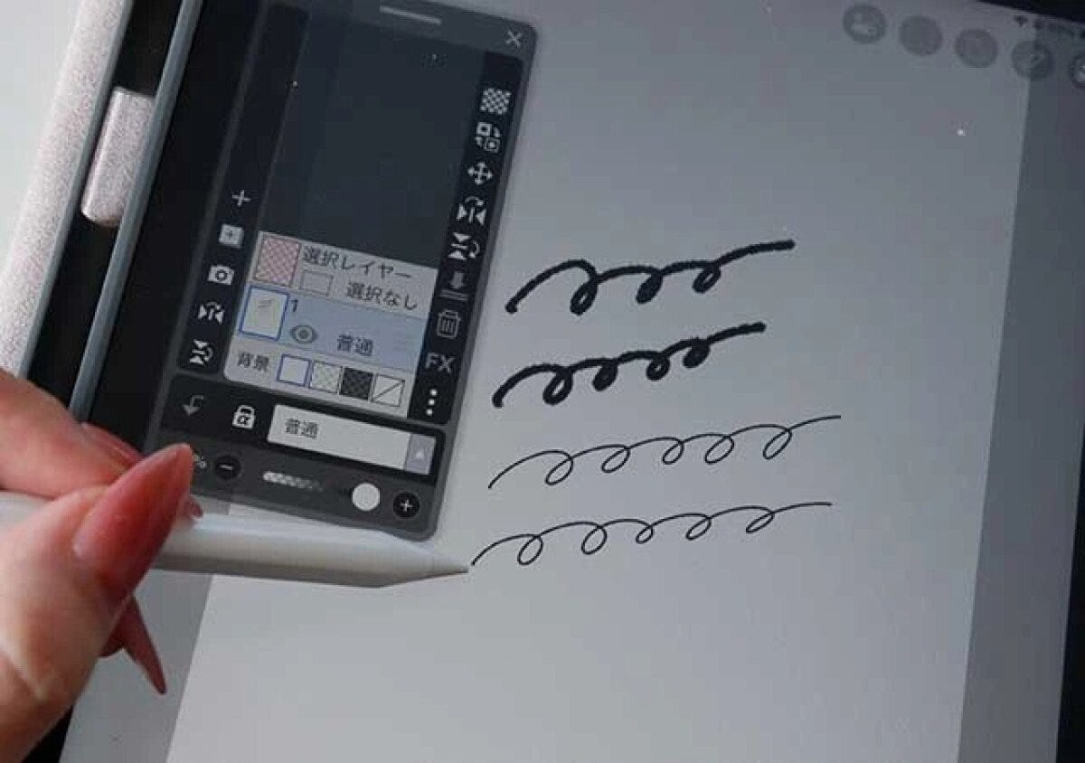 女性が白いタッチペンでiPadの画面に黒い線を書いている