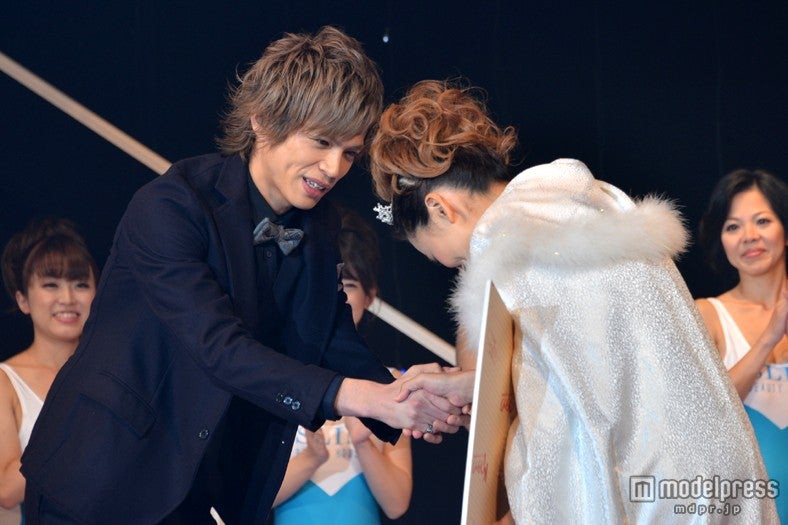 スリムクイーンと握手を交わす山本裕典（左）