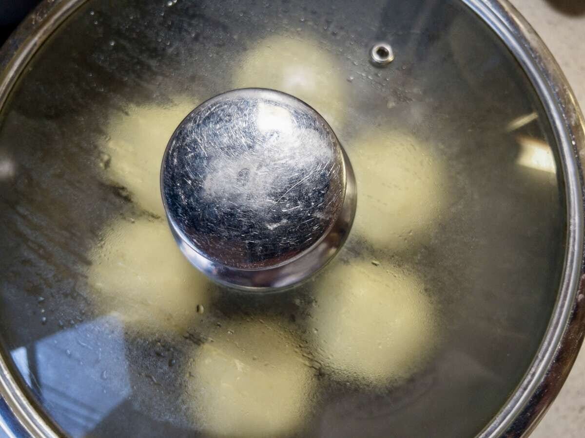 フライパンにフタをして蒸気でパン生地を蒸し焼きにしている俯瞰写真