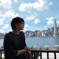 ビクトリア・ハーバー越しに香港を象徴する高層ビル群を望む佐藤健/提供画像