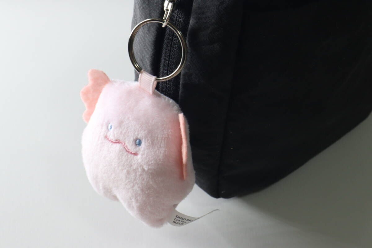 黒いバッグのジッパー部分に取り付けられたマスコットキーホルダー 黒いバッグのジッパー部分に取り付けられたマスコットキーホルダー
