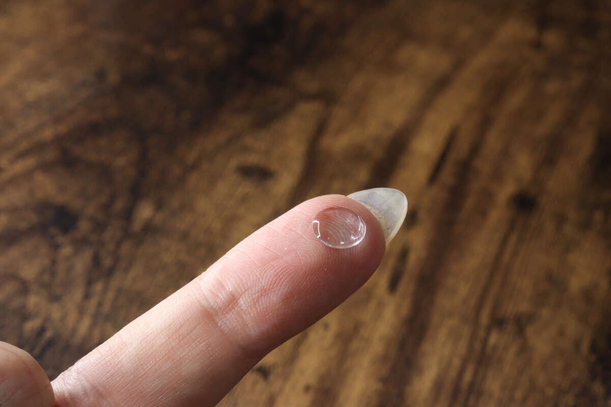 人差し指の先に貼られた透明でぷっくりしたポイントシール。 人差し指の先に貼られた透明でぷっくりしたポイントシール。
