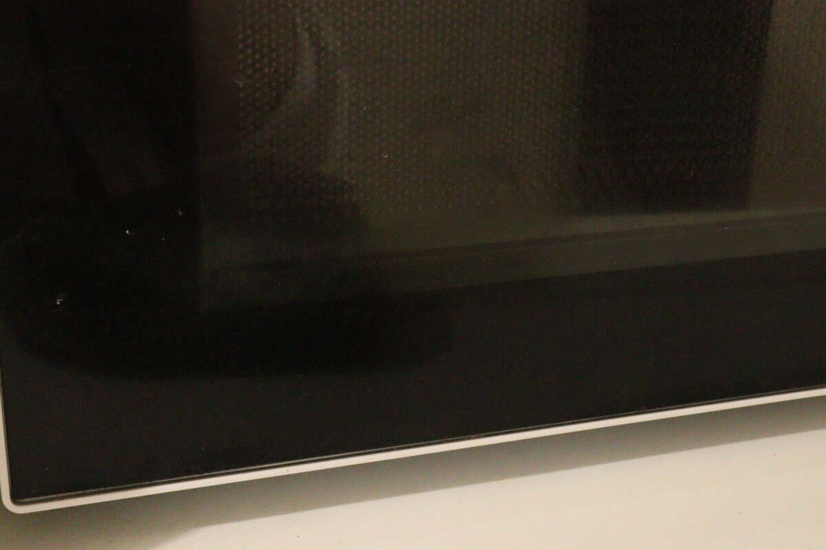 少し汚れや指紋がついている電子レンジの黒いガラス扉の様子