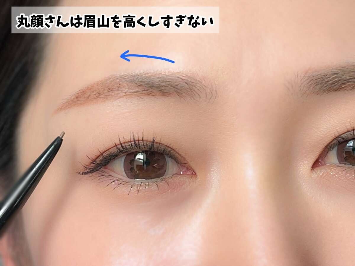 眉ペンシルで眉頭から眉山へ向かって眉を描いている女性の顔のアップ
