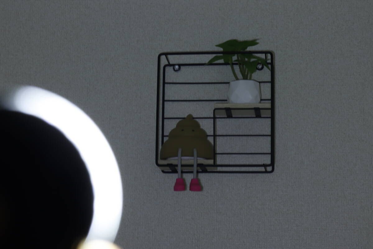 暗い部屋でライトのCOBモードHighを壁の棚に当てて照らしている